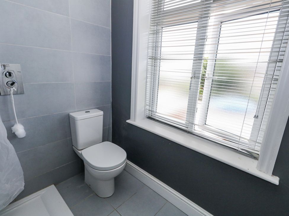 A bathroom with a toilet and shower controls at King Henry House in Lymington