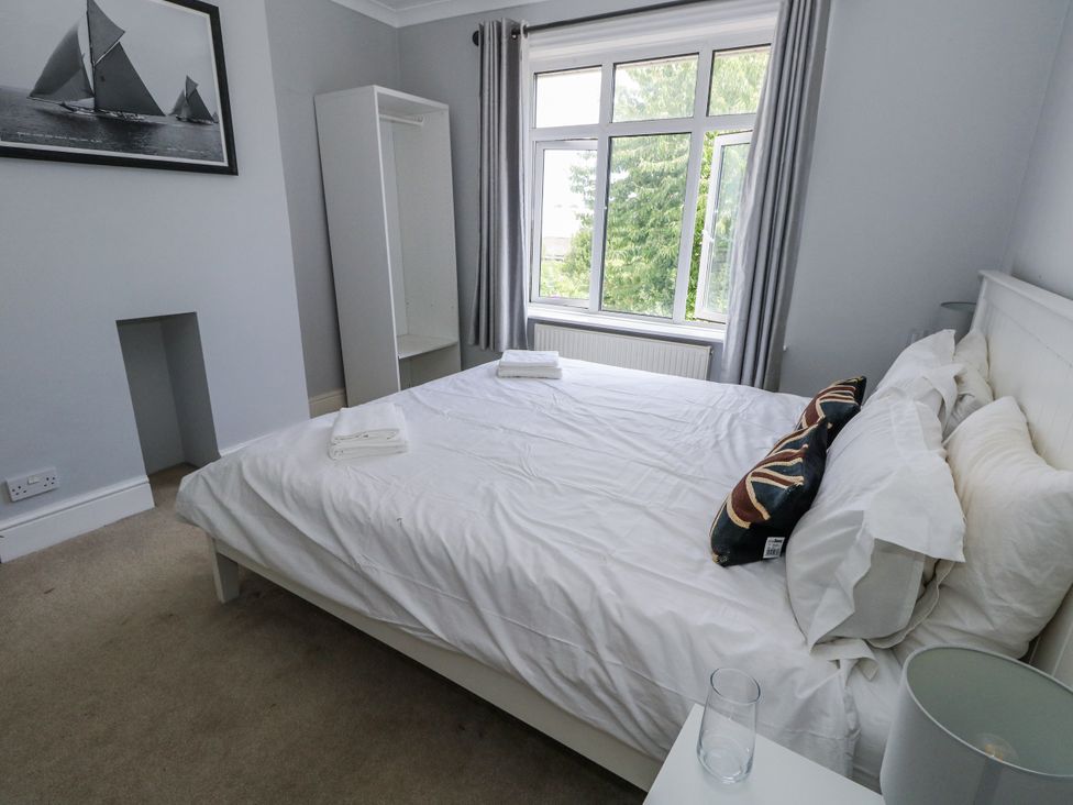 A bedroom with a bed and a wardrobe at King Henry House in Lymington