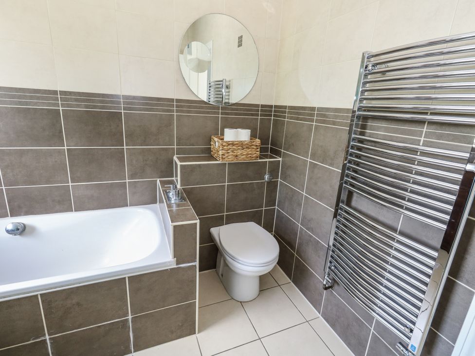 A bathroom with a bathtub and toilet at King Henry House Lymington