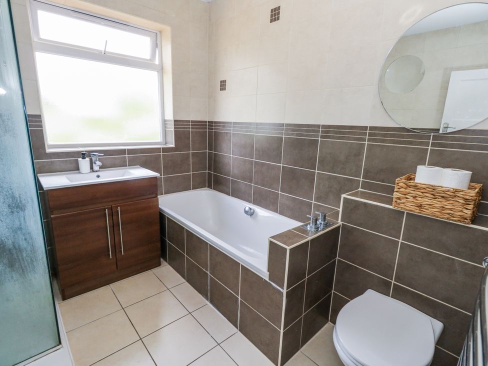 A bathroom with a bathtub, toilet, and sink at King Henry House in Lymington