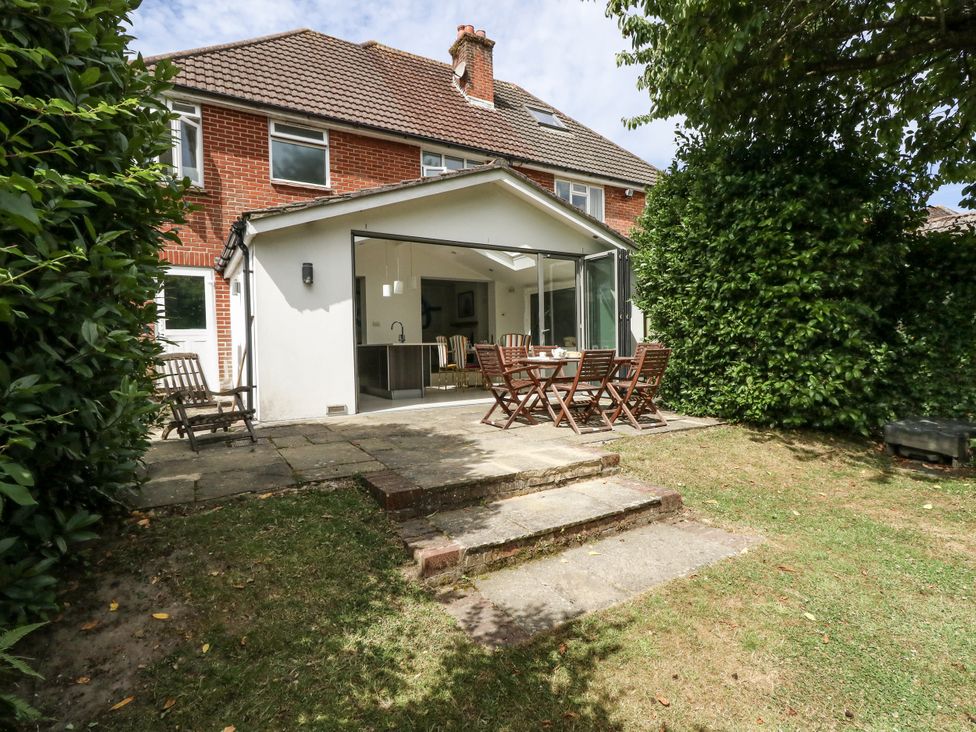 A garden with outdoor seating and steps at King Henry House in Lymington