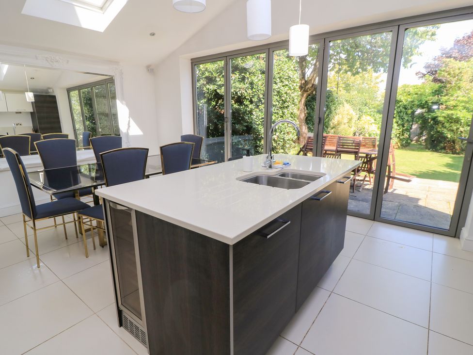A kitchen with an island and dining area at King Henry House in Lymington