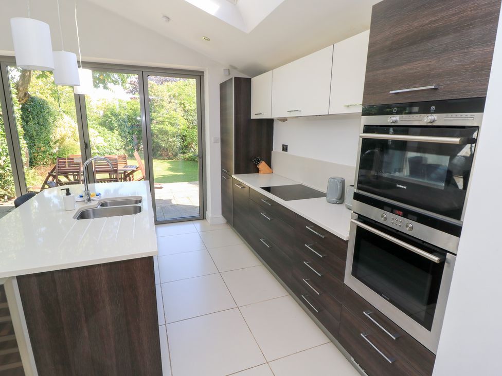 A kitchen with cabinets and modern appliances at King Henry House in Lymington