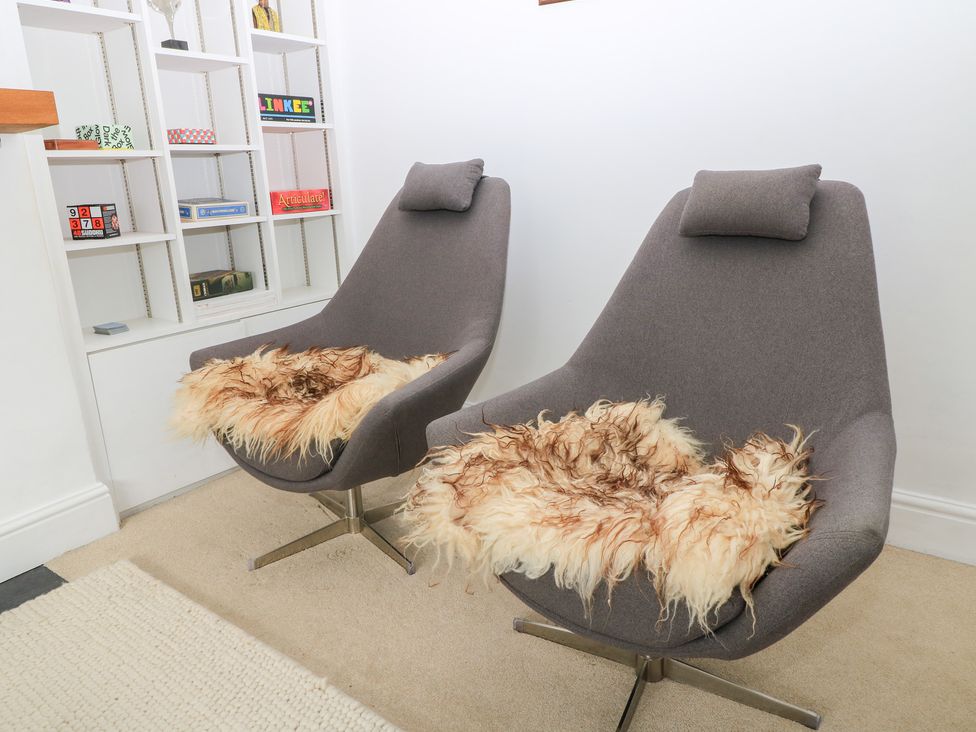 Two chairs with fur seat covers in a living room at King Henry House in Lymington