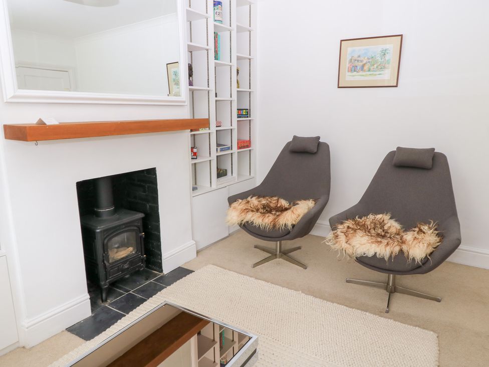 A living room with armchairs and a fireplace at King Henry House in Lymington