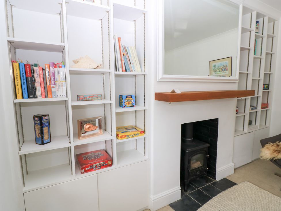 A living room with bookshelves and a fireplace at King Henry House in Lymington