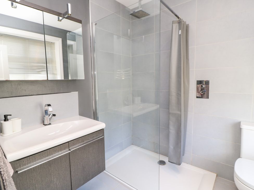 A bathroom with a shower, sink, and toilet at King Henry House, Lymington