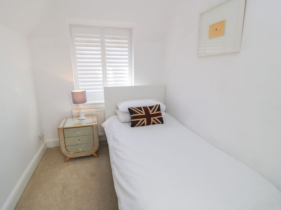 A bedroom with a bed and a nightstand at King Henry House in Lymington