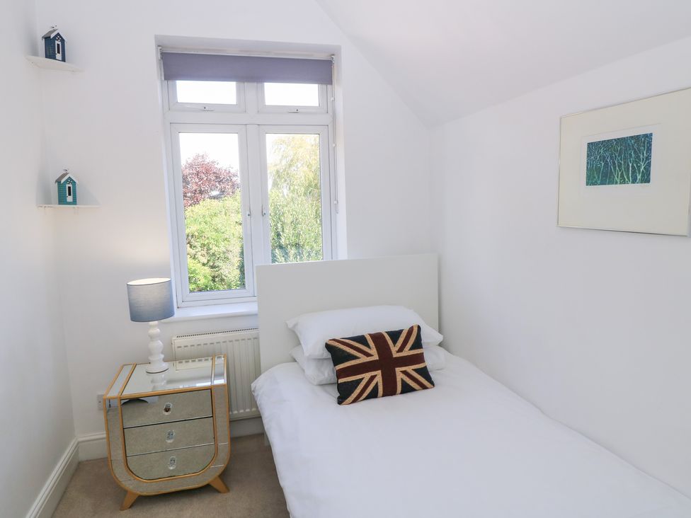 A bedroom with a bed and a nightstand at King Henry House in Lymington