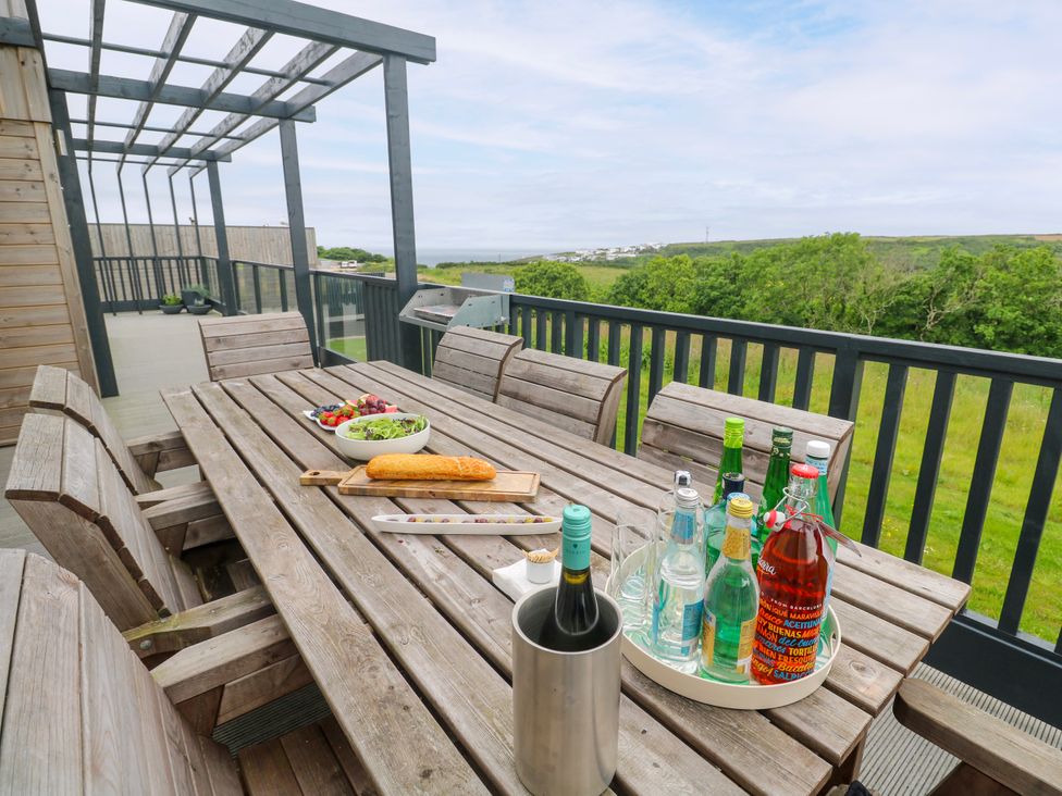 An outdoor dining area with a table and drinks at Dahlia in Portreath