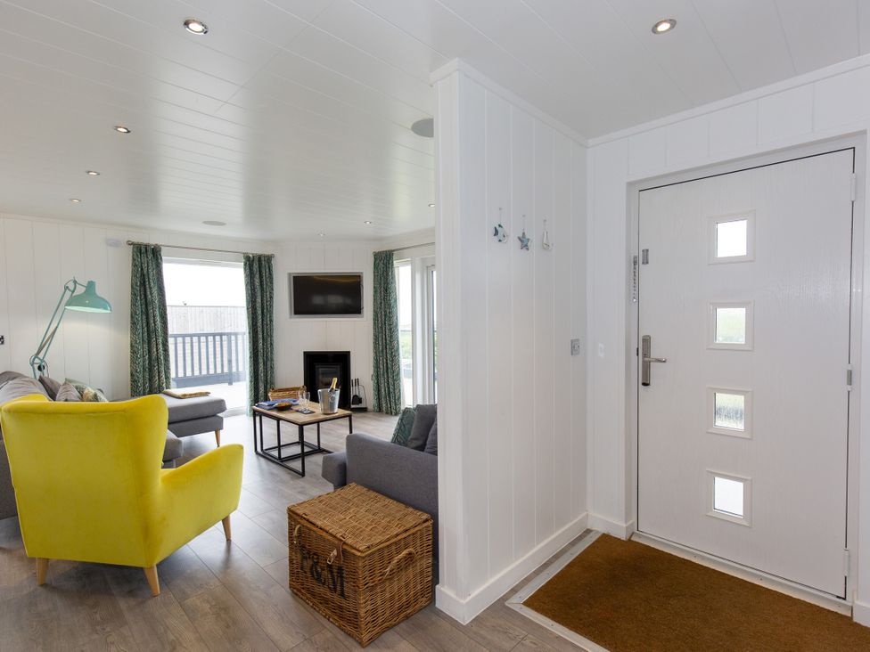 A living room with furniture and a door at Dahlia in Portreath