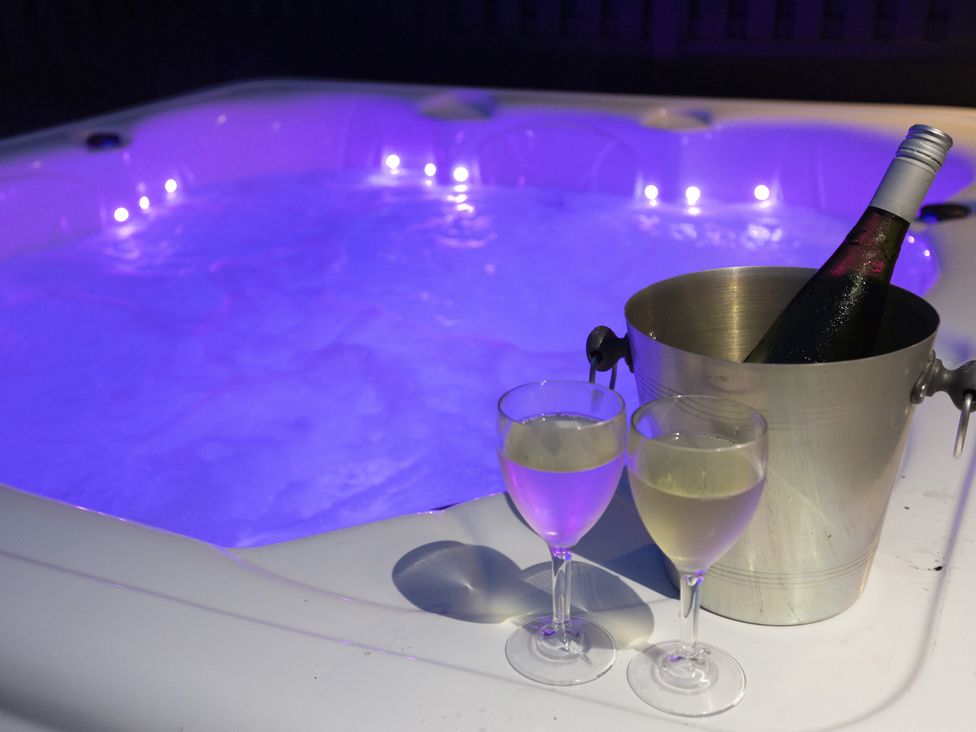 A hot tub with champagne and glasses at Dahlia in Portreath
