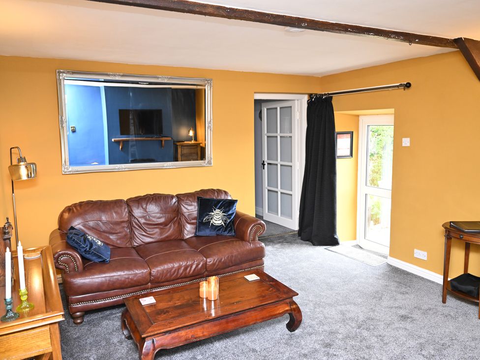 A living room with a sofa and coffee table at Petty Knowes Cottage in Rochester near Otterburn