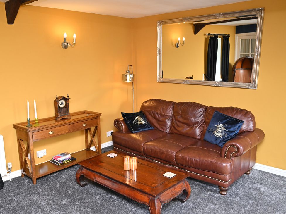 A living room with a couch and coffee table at Petty Knowes Cottage Rochester near Otterburn
