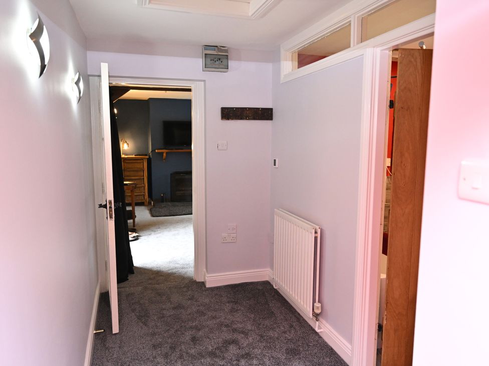 A hallway with doors and a radiator at Petty Knowes Cottage in Rochester near Otterburn