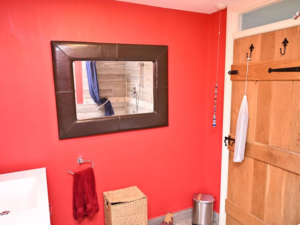 A bathroom with a sink and a mirror at Petty Knowes Cottage near Rochester near Otterburn