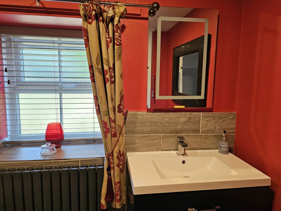 A bathroom with a sink and window at Petty Knowes Cottage Rochester near Otterburn
