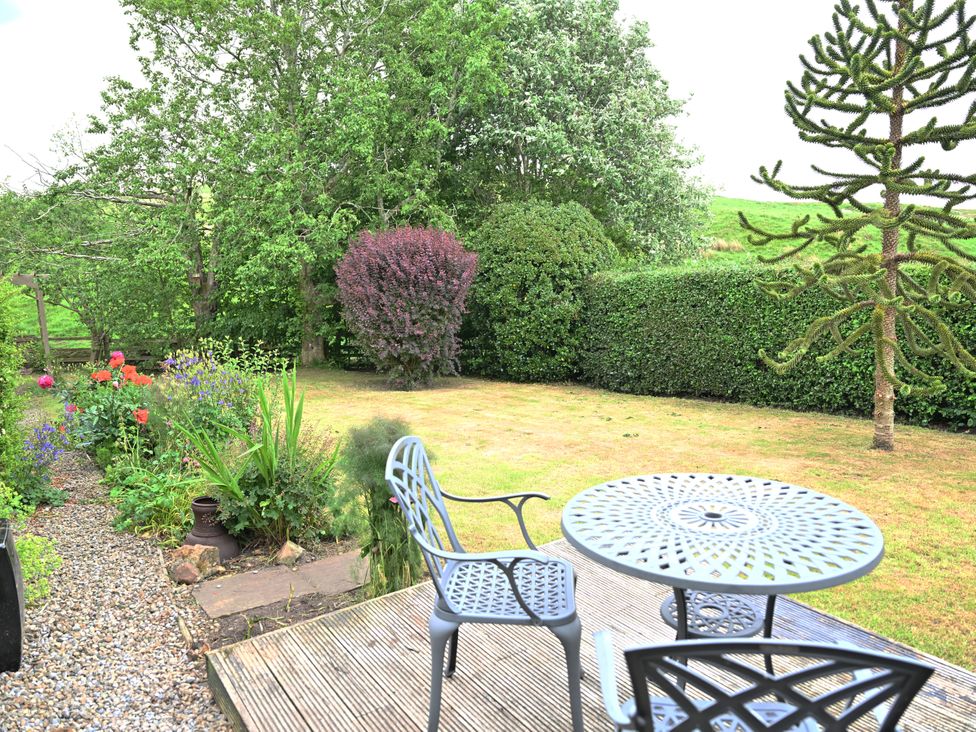 A garden with a table and chairs at Petty Knowes Cottage Rochester near Otterburn