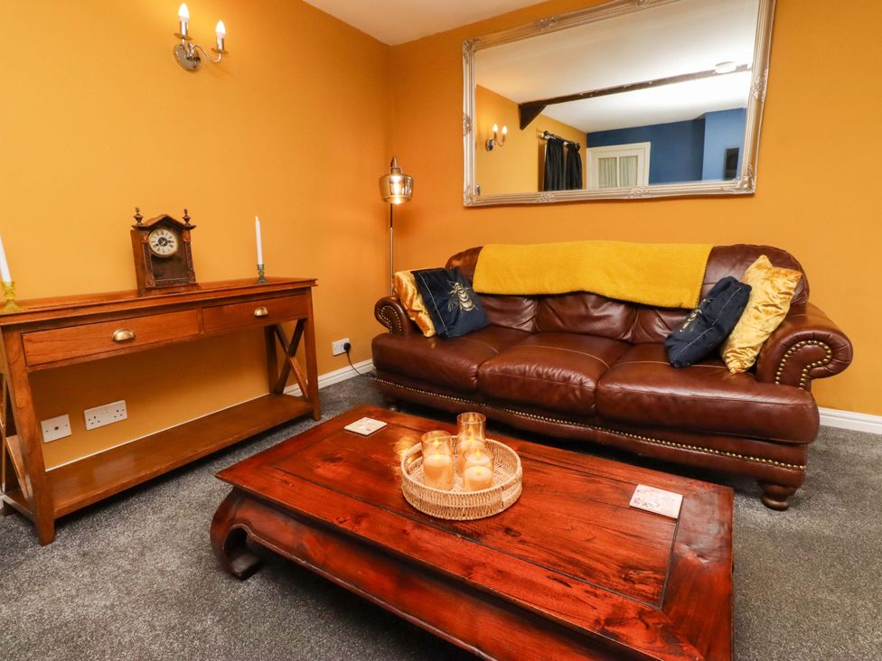 A living room with a sofa and coffee table at Petty Knowes Cottage near Rochester
