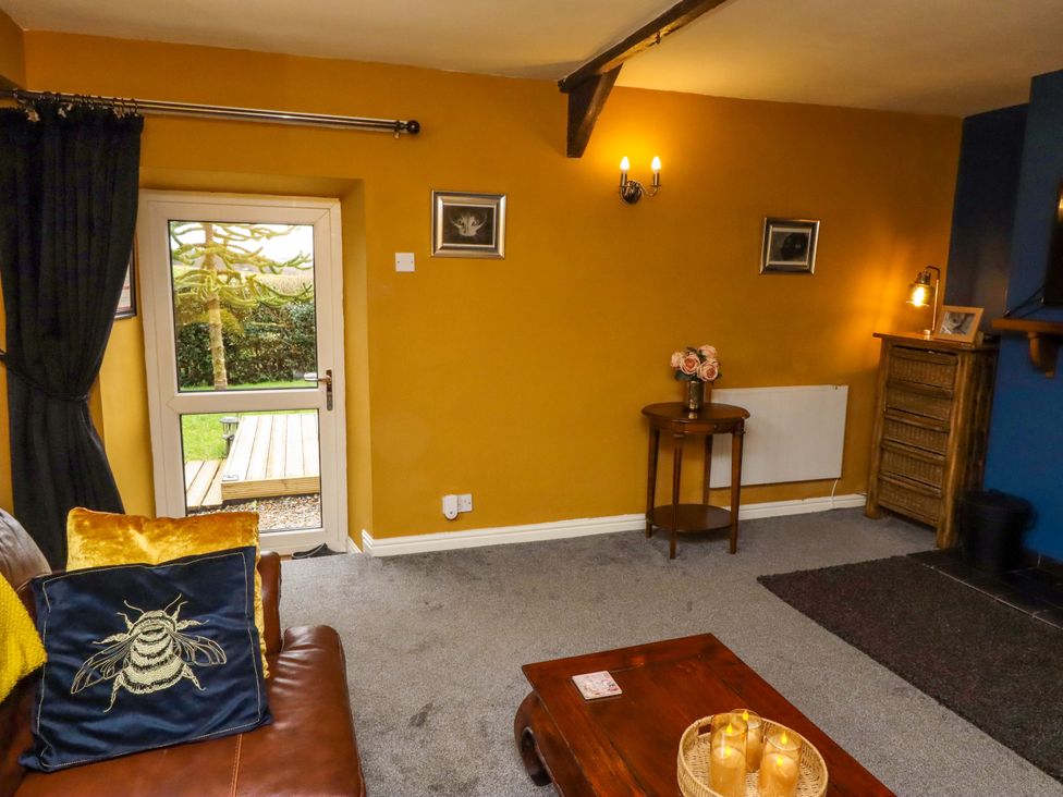 A living room with a sofa and candles at Petty Knowes Cottage Rochester near Otterburn
