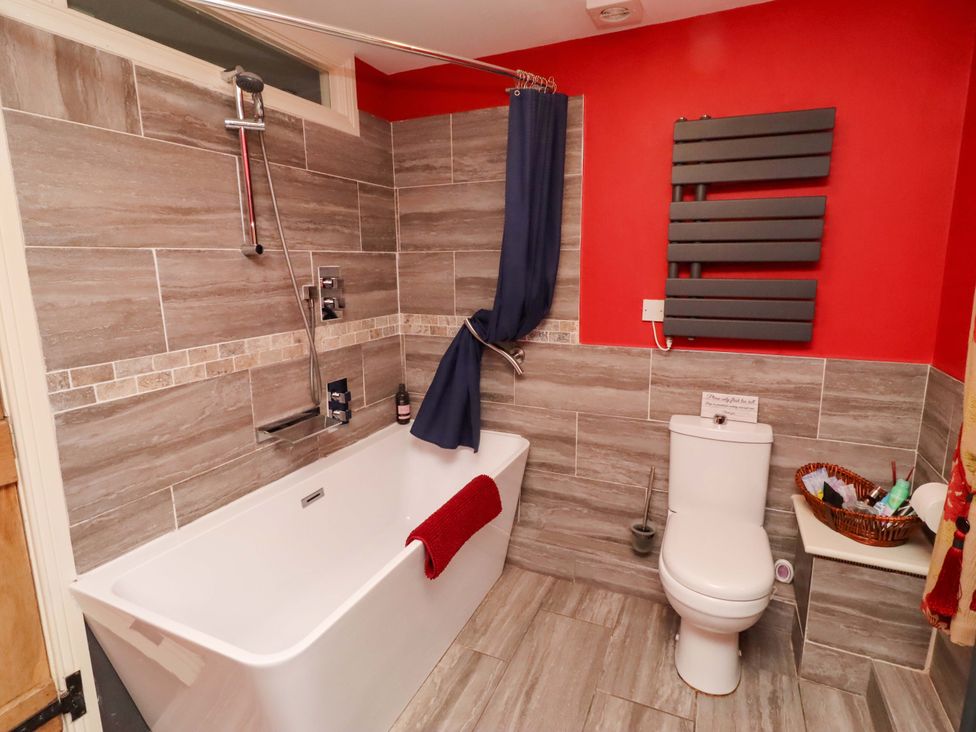 A bathroom with a bath tub and shower at Petty Knowes Cottage near Rochester