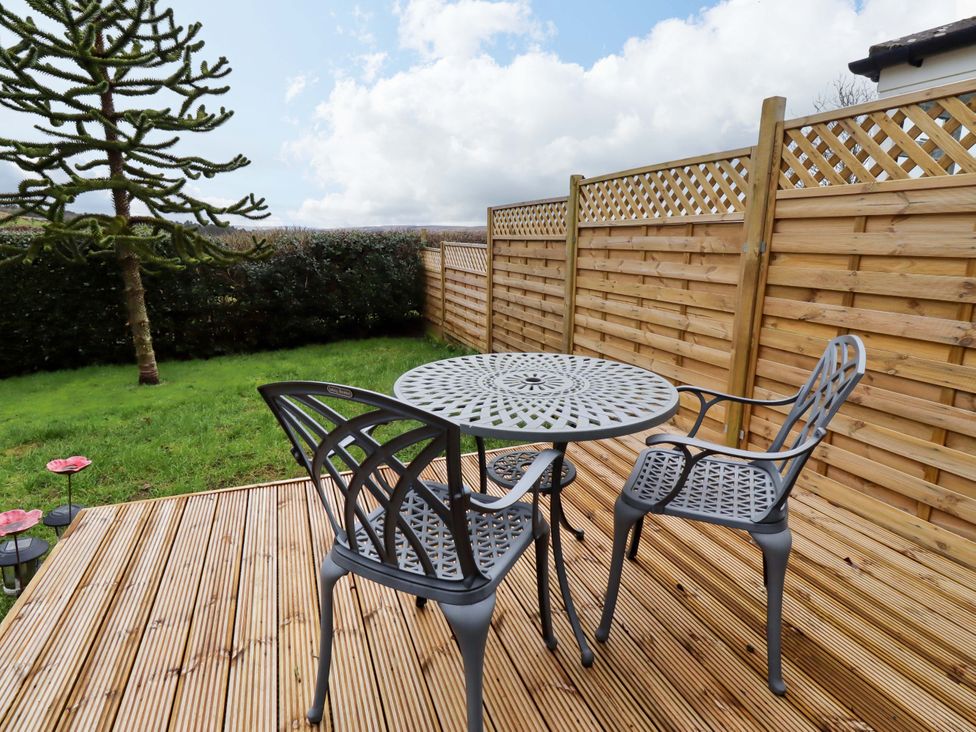 A garden with a table and chairs and a fence at Petty Knowes Cottage Rochester near Otterburn