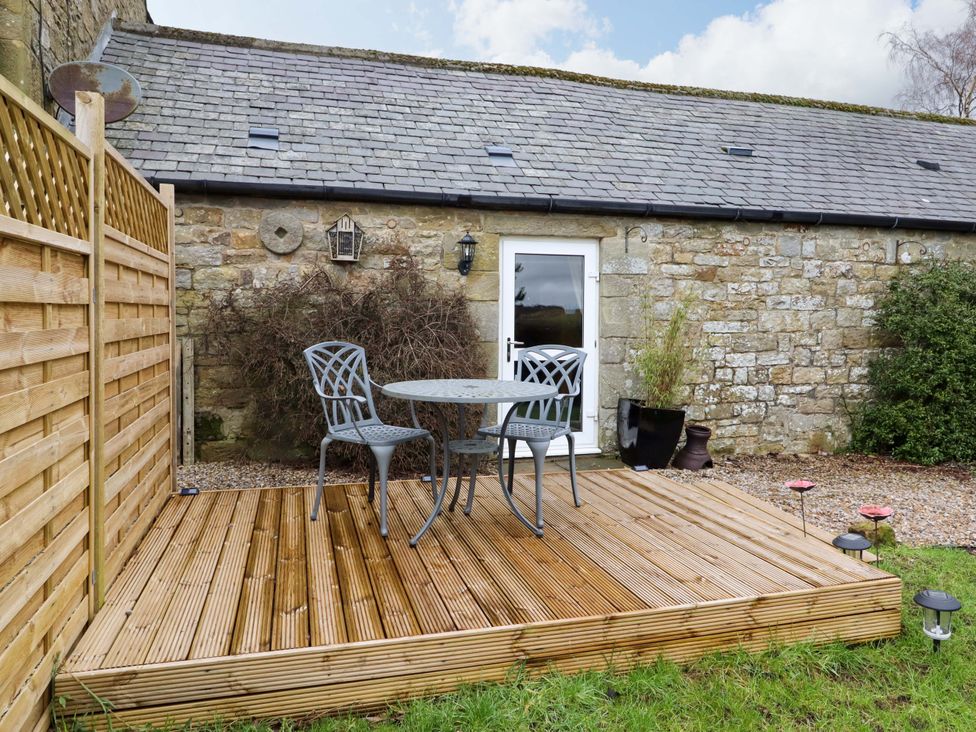 A deck with a table and chairs at Petty Knowes Cottage Rochester near Otterburn