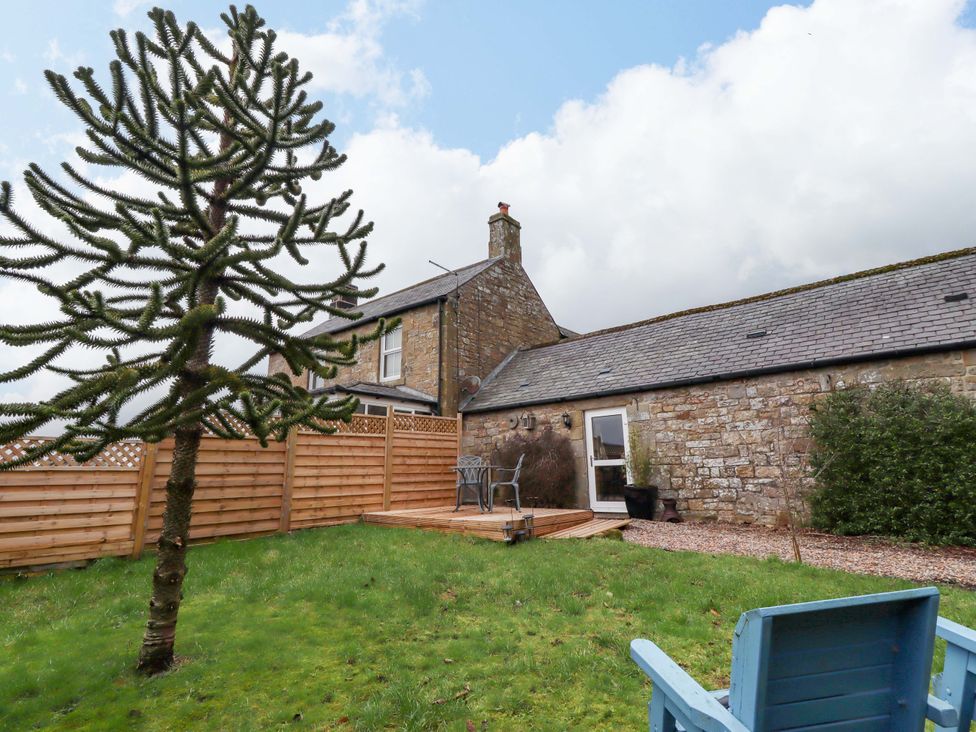A garden with a decking area and outdoor furniture at Petty Knowes Cottage near Rochester