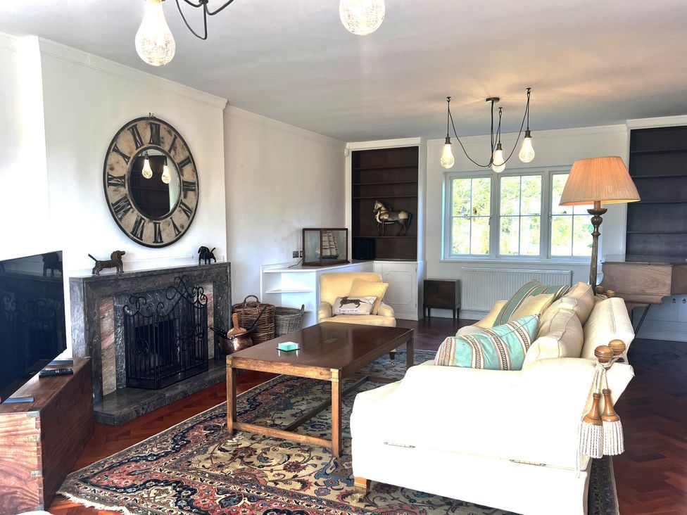 A living room with a fireplace and sofa at Higher Park Farm in Alderley Edge