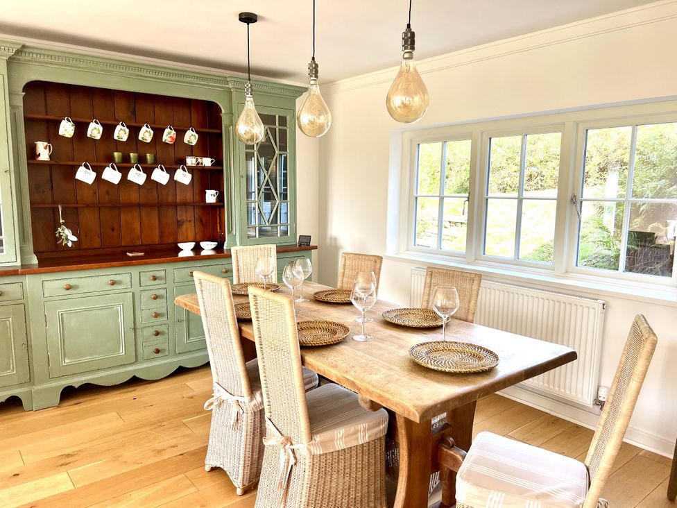 A dining room with a wooden table and chairs at Higher Park Farm in Alderley Edge