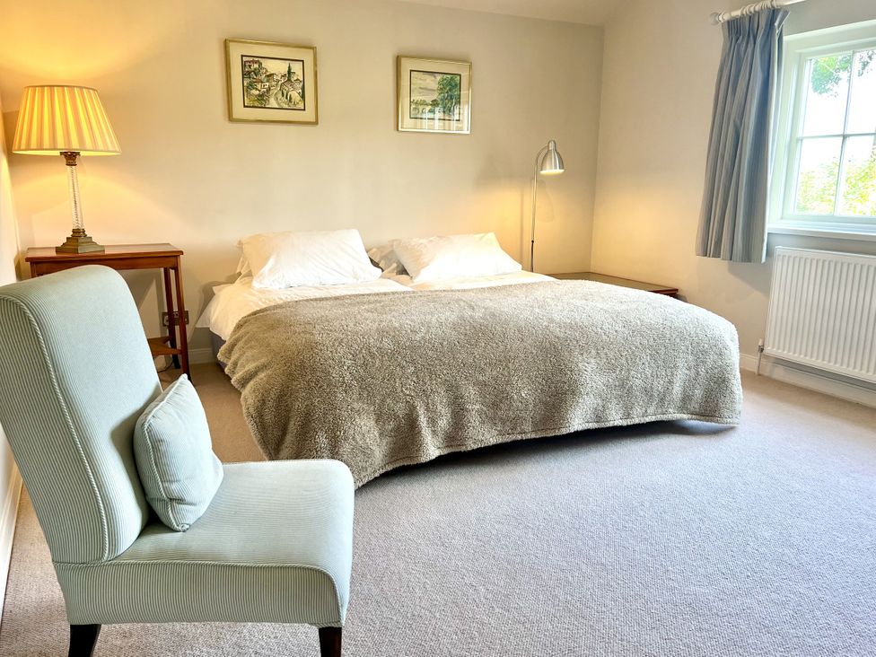 A bedroom with a bed and a lamp at Higher Park Farm in Alderley Edge