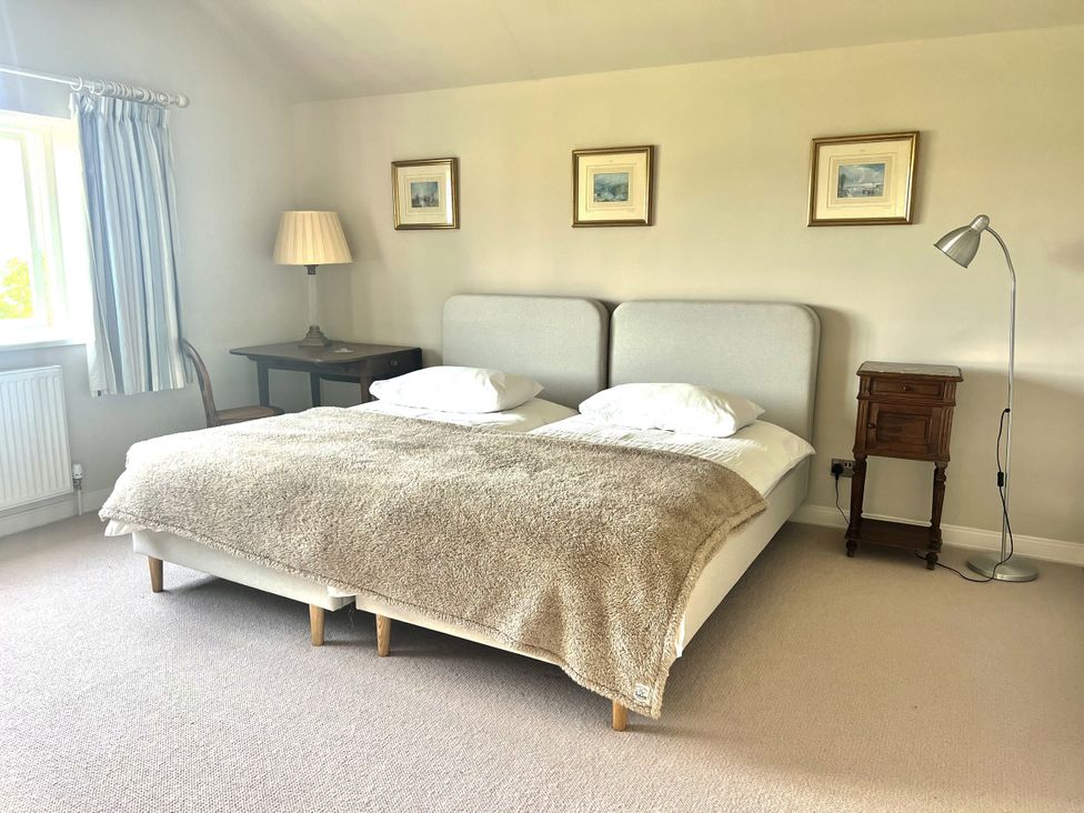 A bedroom with a bed and bedside table at Higher Park Farm, Alderley Edge
