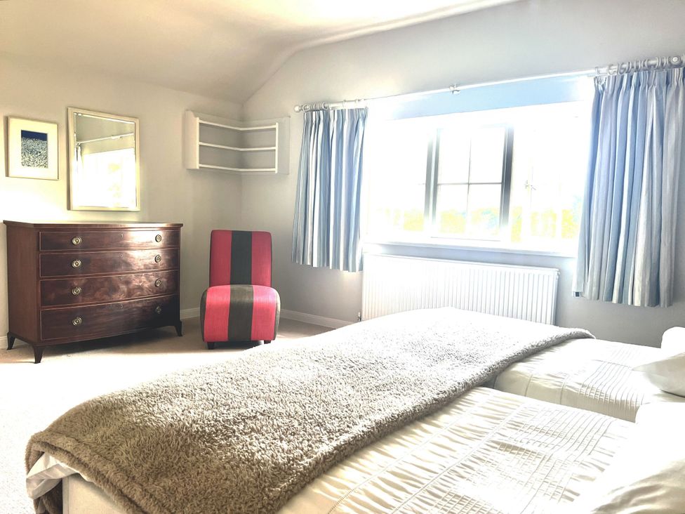 A bedroom with a dresser and two beds at Higher Park Farm Alderley Edge