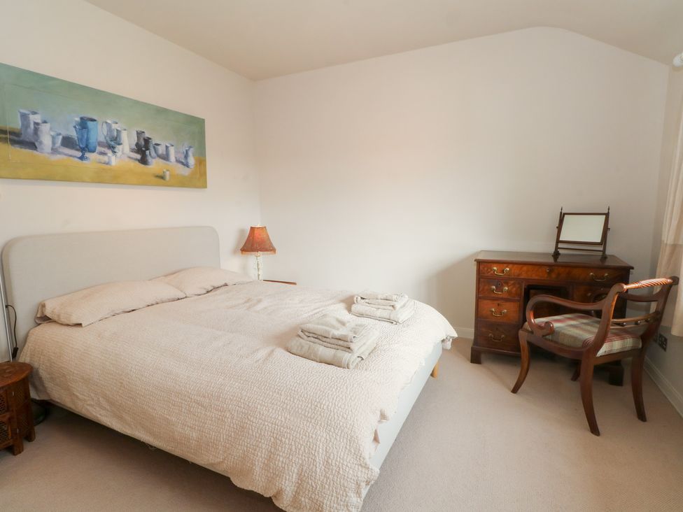 A bedroom with a bed and dresser at Higher Park Farm in Alderley Edge