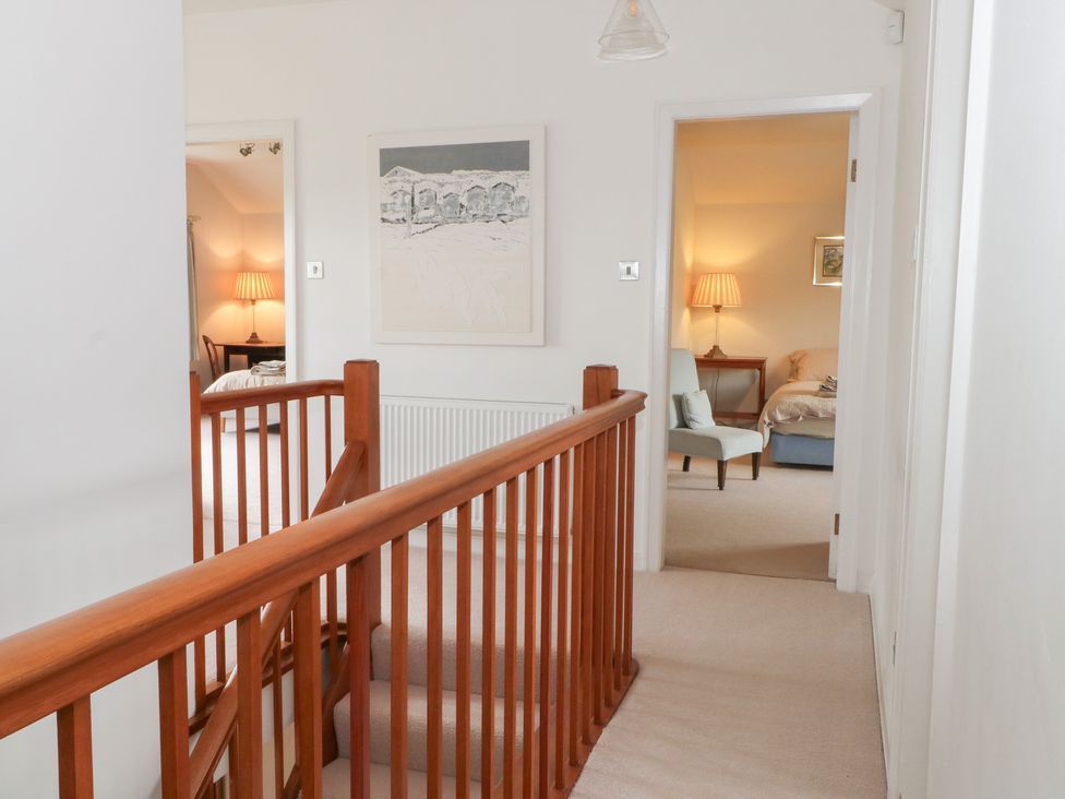 A corridor with a staircase and doors leading to rooms at Higher Park Farm in Alderley Edge