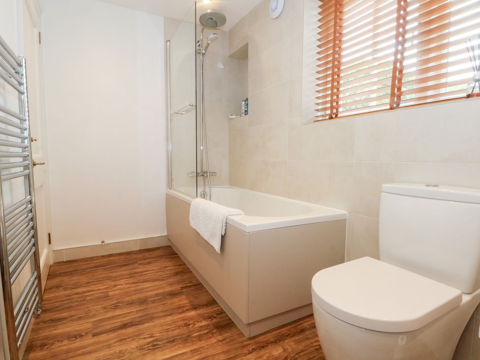 A bathroom with a bathtub and toilet at Higher Park Farm in Alderley Edge