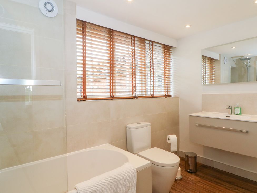 A bathroom with a bathtub, toilet, and sink at Higher Park Farm in Alderley Edge