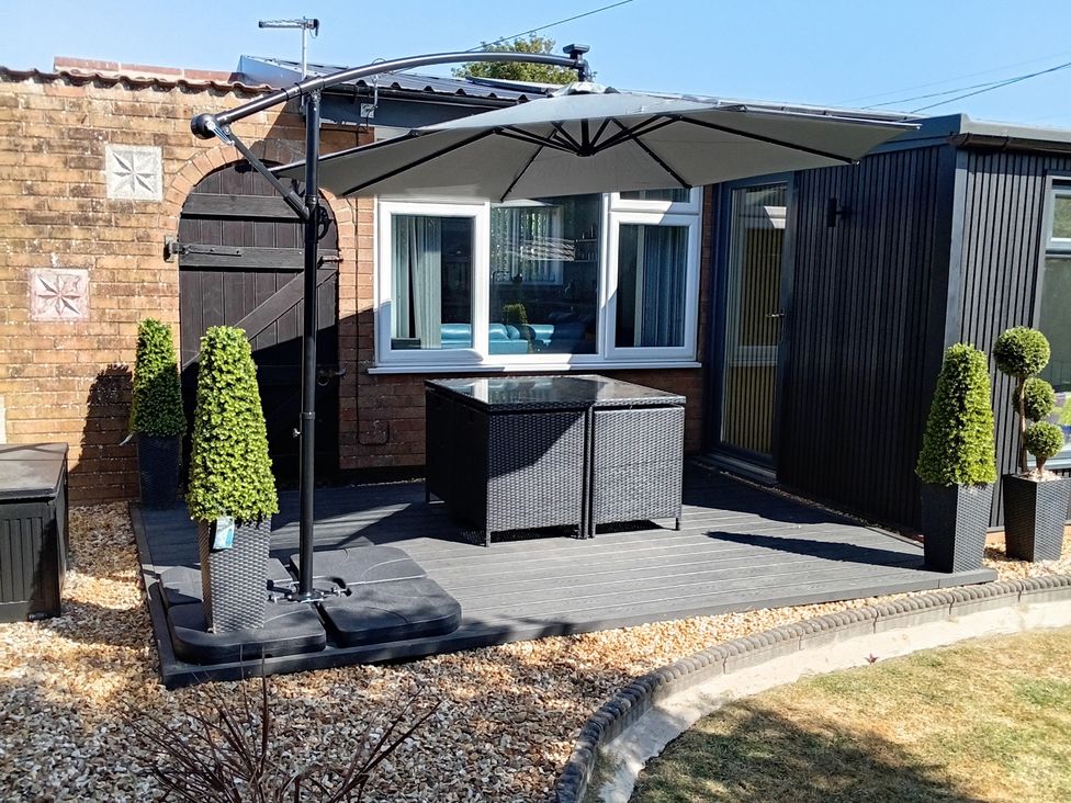 A garden with a parasol and table at 19 The Court Anderby Creek