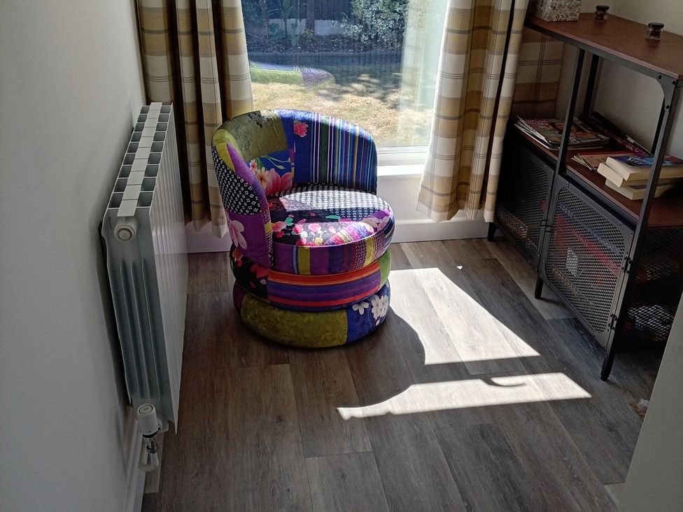 A snug with a colorful chair and radiator at 19 The Court in Anderby Creek