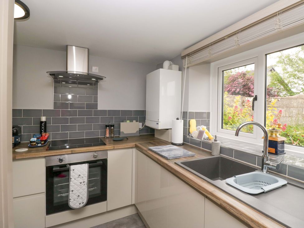 A kitchen with cabinets and an oven at Yeat Stoup Cottage in Cockermouth