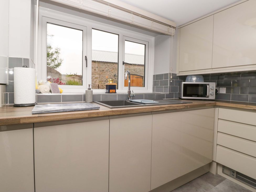 A kitchen with a sink and cabinets at Yeat Stoup Cottage in Cockermouth