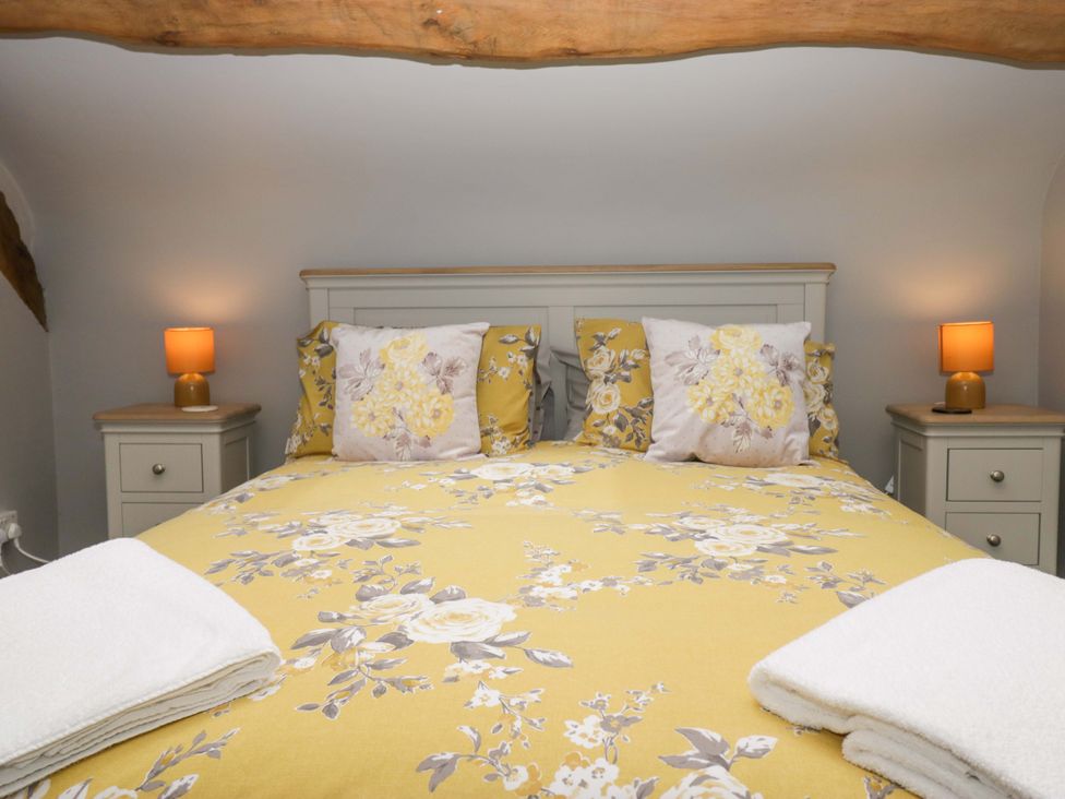 A bedroom with a double bed and bedside tables at Yeat Stoup Cottage in Cockermouth