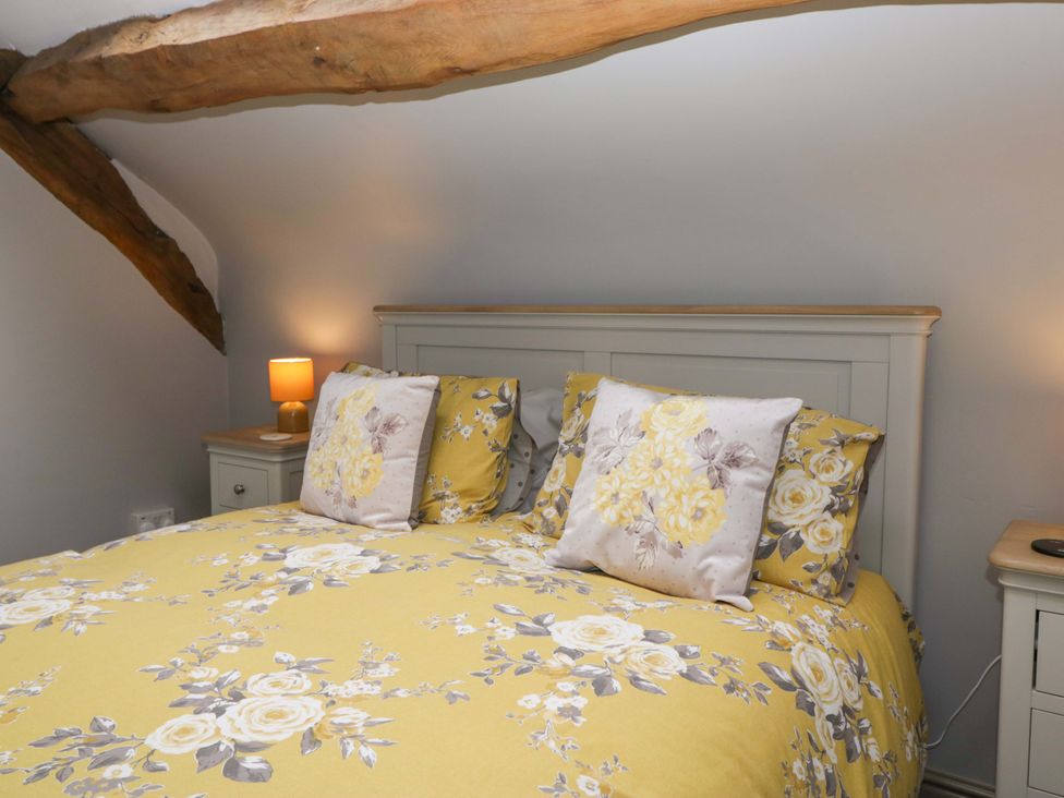 A bedroom with a bed and bedside table at Yeat Stoup Cottage in Cockermouth