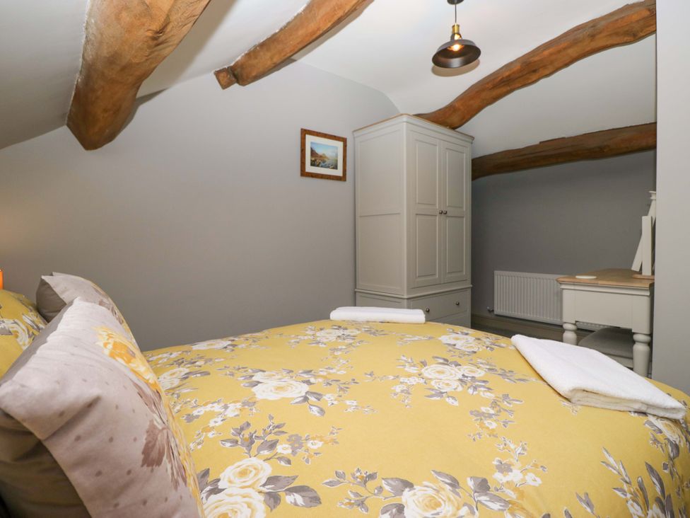 A bedroom with a bed and wardrobe at Yeat Stoup Cottage in Cockermouth