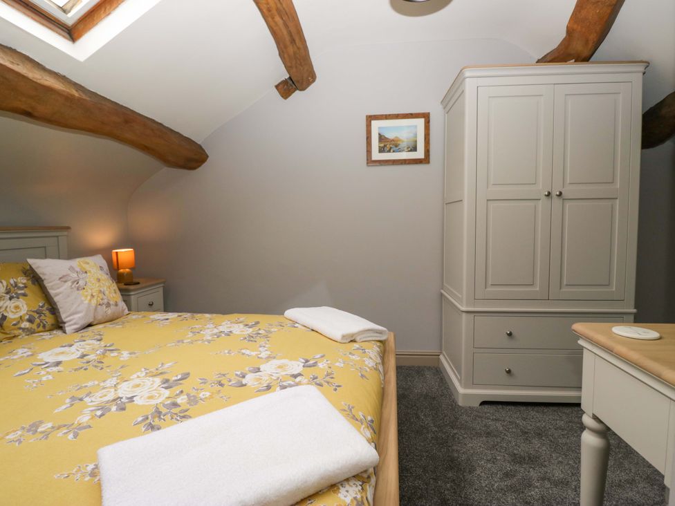 A bedroom with a double bed and wardrobe at Yeat Stoup Cottage Cockermouth