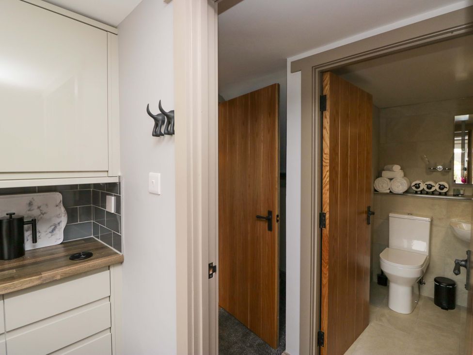 A bathroom with a toilet and towels at Yeat Stoup Cottage in Cockermouth