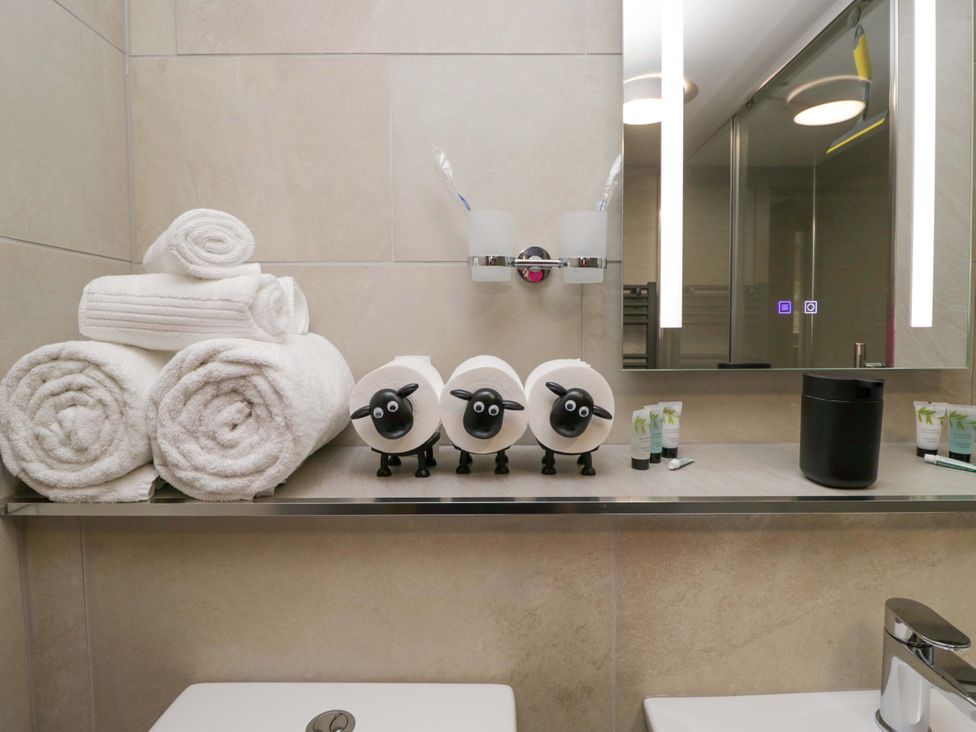 A bathroom with towels and grooming products at Yeat Stoup Cottage in Cockermouth