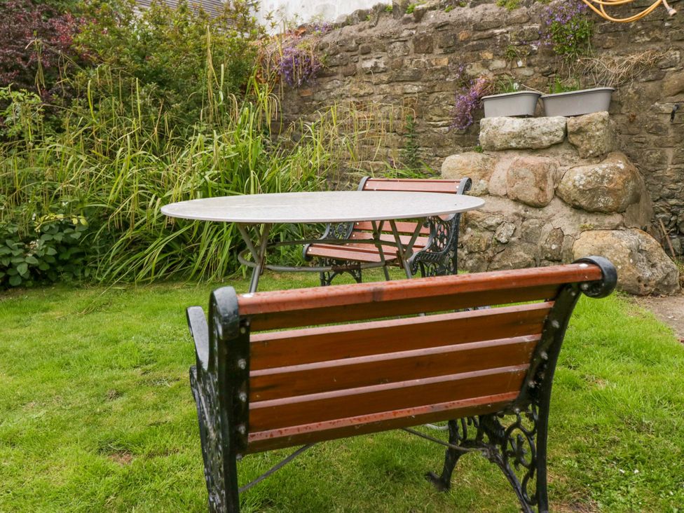 A garden with a table and benches at Yeat Stoup Cottage in Cockermouth