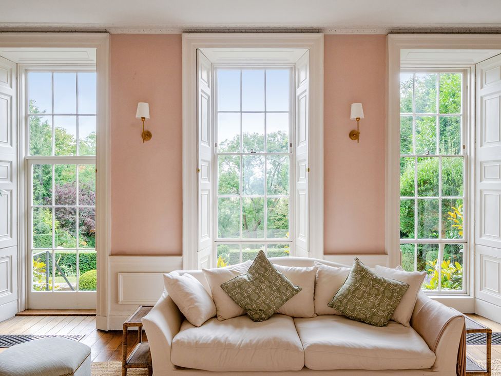 A living room with a sofa and windows at Batheaston House in Batheaston