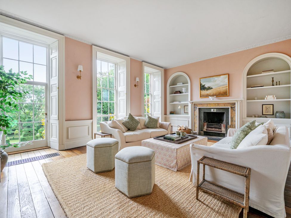 A living room with a fireplace and shelves at Batheaston House in Batheaston
